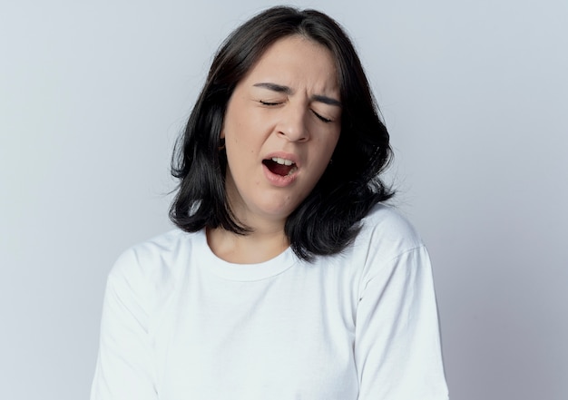 Jovem bonita caucasiana cansada bocejando com os olhos fechados, isolada no fundo branco