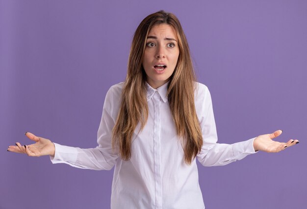 Jovem bonita caucasiana decepcionada com as mãos abertas e olhando para o lado