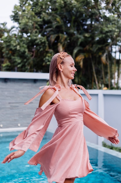 Foto grátis jovem bonita caucasiana romântica sozinha em um lindo vestido de verão de férias em villa de luxo