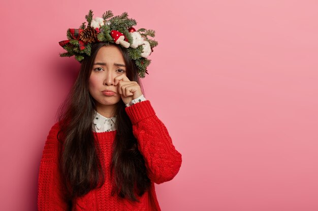 Jovem bonita com guirlanda de Natal na cabeça