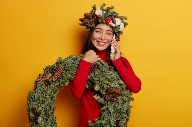 Jovem bonita com guirlanda de natal na cabeça