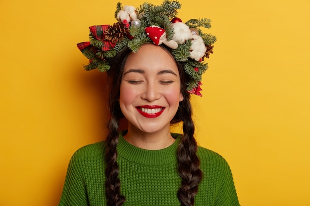 Jovem bonita com guirlanda de Natal na cabeça