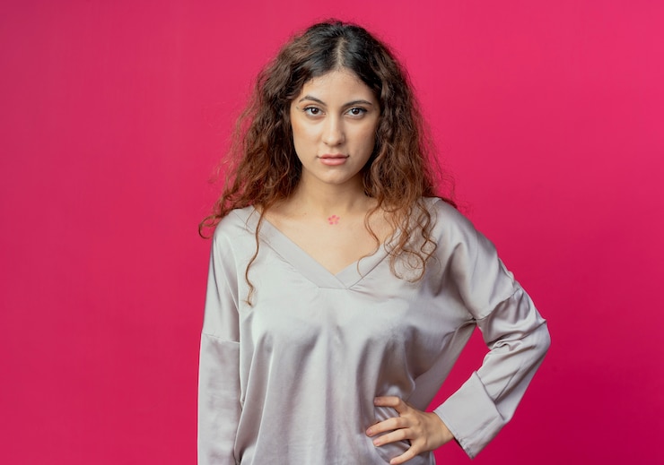 Foto grátis jovem bonita confiante colocando a mão no quadril isolado em um fundo rosa