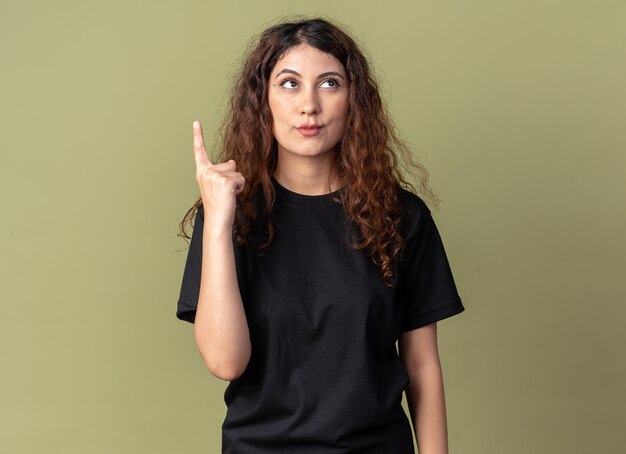 Jovem bonita impressionada olhando e apontando para cima