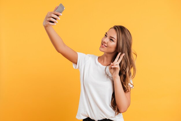 Jovem bonita muito bonita fazer selfie por telefone móvel