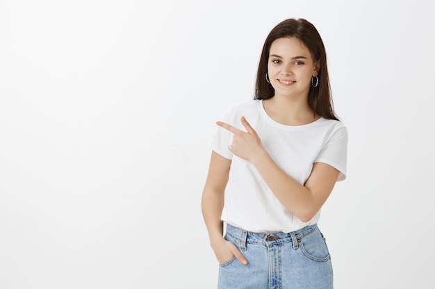 Jovem bonita posando contra uma parede branca