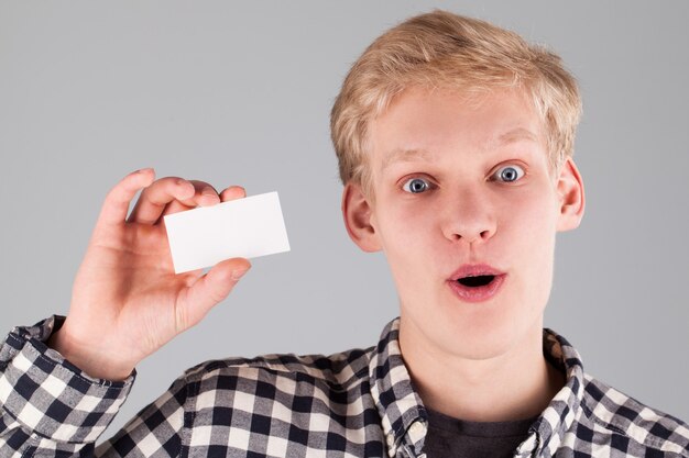 Jovem bonitão segurando um cartão em branco