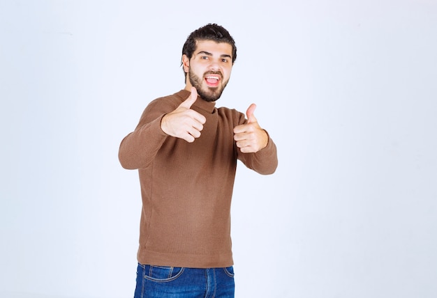 Jovem bonito com polegares para cima