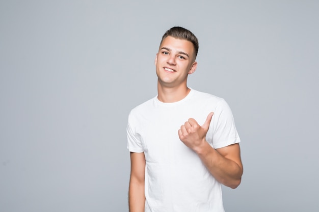 Jovem bonito com uma camiseta branca isolada no branco se propõe a fazer algo