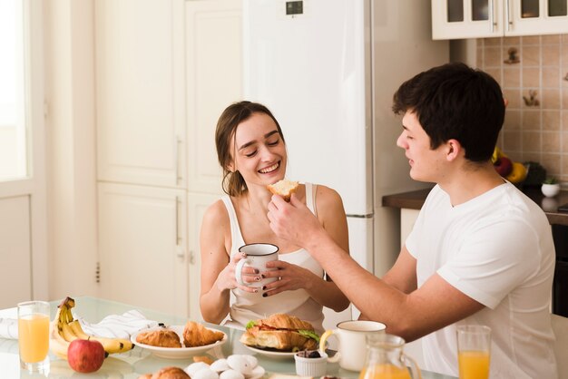 Jovem bonito e mulher tomando café da manhã