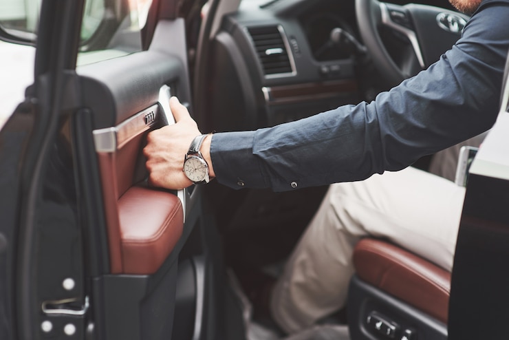Foto grátis jovem bonito em terno completo enquanto dirige um carro.