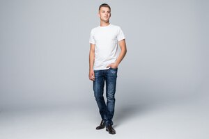 Jovem bonito em uma roupa de estilo casual camiseta branca e jeans azul branco