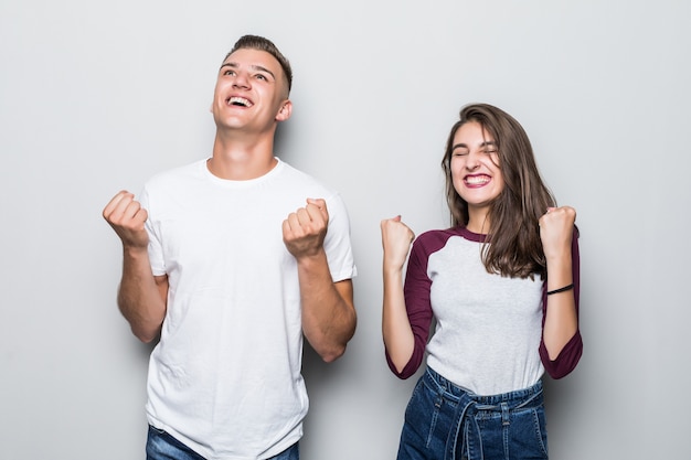 Jovem bonito feliz vitória casal menino e menina isolados no branco