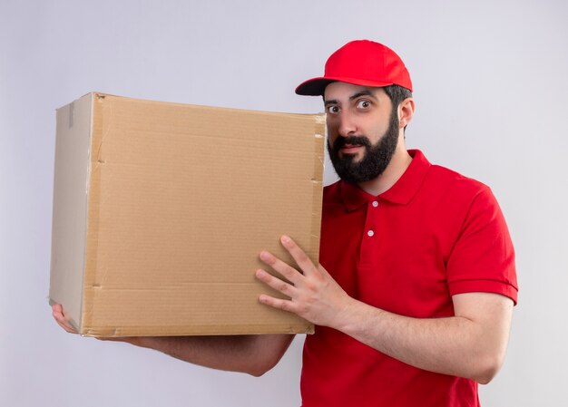 Jovem, bonito, jovem, homem, caucasiano, entregador, impressionado, vestindo, uniforme, vermelho
