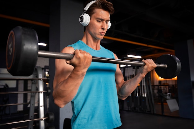 Foto grátis jovem bonito malhando na academia de musculação