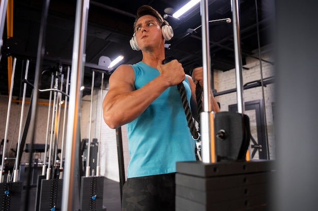 Jovem bonito malhando na academia de musculação