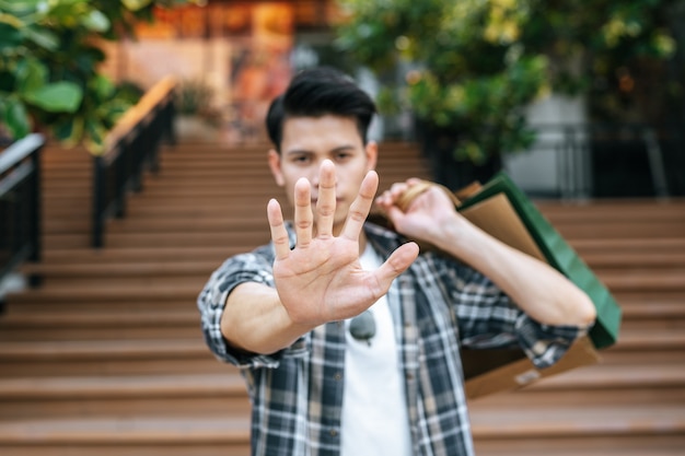 Foto grátis jovem bonito segurando vários sacos de papel