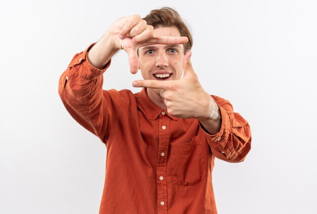 Jovem bonito sorridente usando uma camisa vermelha e mostrando um gesto com uma foto