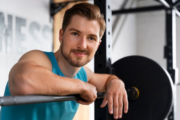 Jovem bonito treinando na academia para musculação