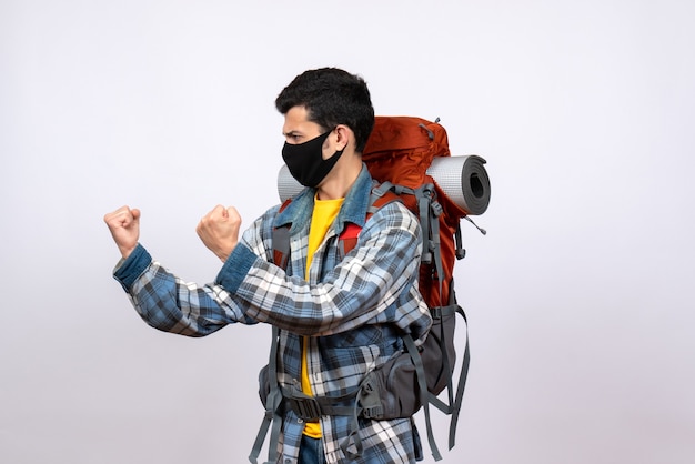 Jovem caminhante zangado de frente com mochila e máscara pronta para lutar