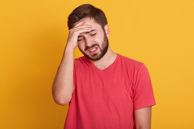 Jovem cansado mantém a mão na testa