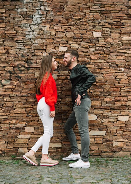 Jovem casal apaixonado na frente da parede de tijolos