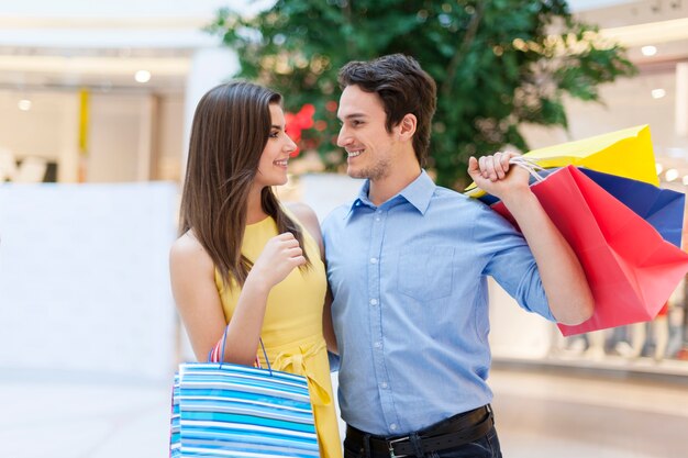 Jovem casal apaixonado por sacolas de compras