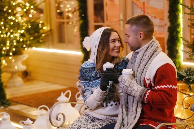 Jovem casal atraente passando tempo juntos no dia de Natal perto da árvore de Natal.