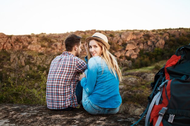 Jovem casal bonito de viajantes apreciando a vista do canyon, sorrindo