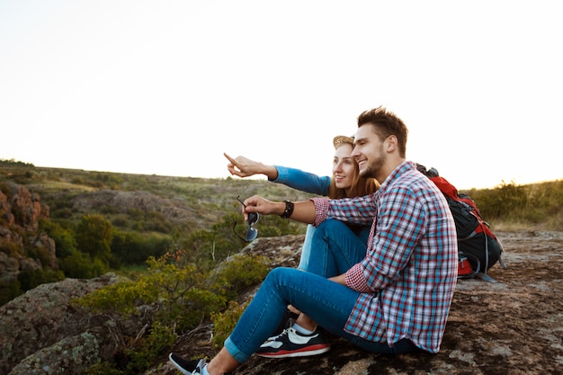 Jovem casal bonito de viajantes apreciando a vista do canyon, sorrindo