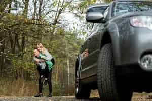 Foto grátis jovem casal brincando atrás de um carro