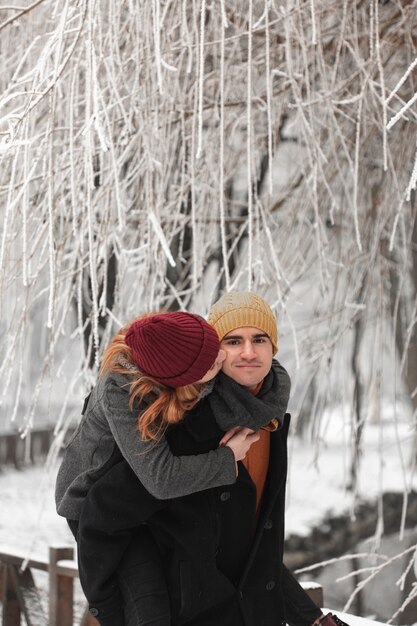 Jovem casal brincando na paisagem de inverno