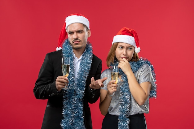 Jovem casal comemorando ano novo na parede vermelha