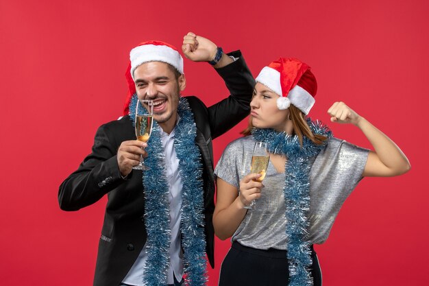 Jovem casal comemorando ano novo no feriado de parede vermelha ama o Natal