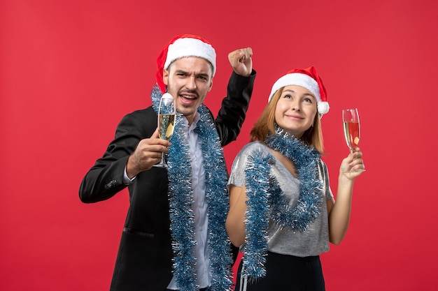 Jovem casal comemorando ano novo no piso vermelho, festa de Natal, amor