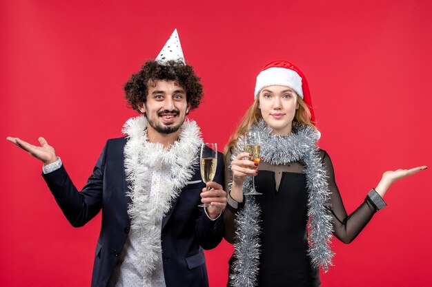 Jovem casal comemorando o ano novo na mesa vermelha. Foto de amor de natal