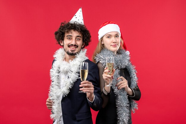 Jovem casal comemorando o ano novo na parede vermelha