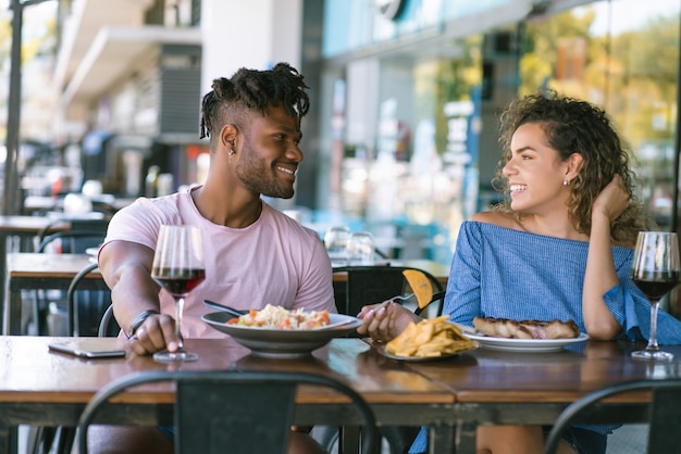 Jovem casal conversando e curtindo enquanto almoçavam juntos em um restaurante.