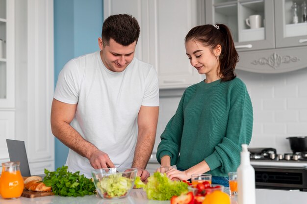 Jovem casal cozinhando em casa