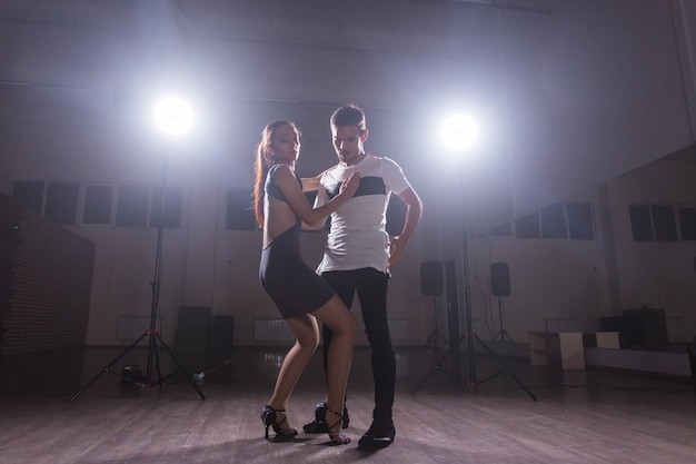 Jovem casal dançando dança latina bachata, merengue, salsa. dois pose de elegância na aula de dança.