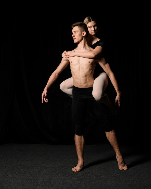 Jovem casal de balé posando em trajes de balé