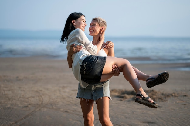 Casal de lésbicas amoroso em um encontro à beira-mar e montanhas