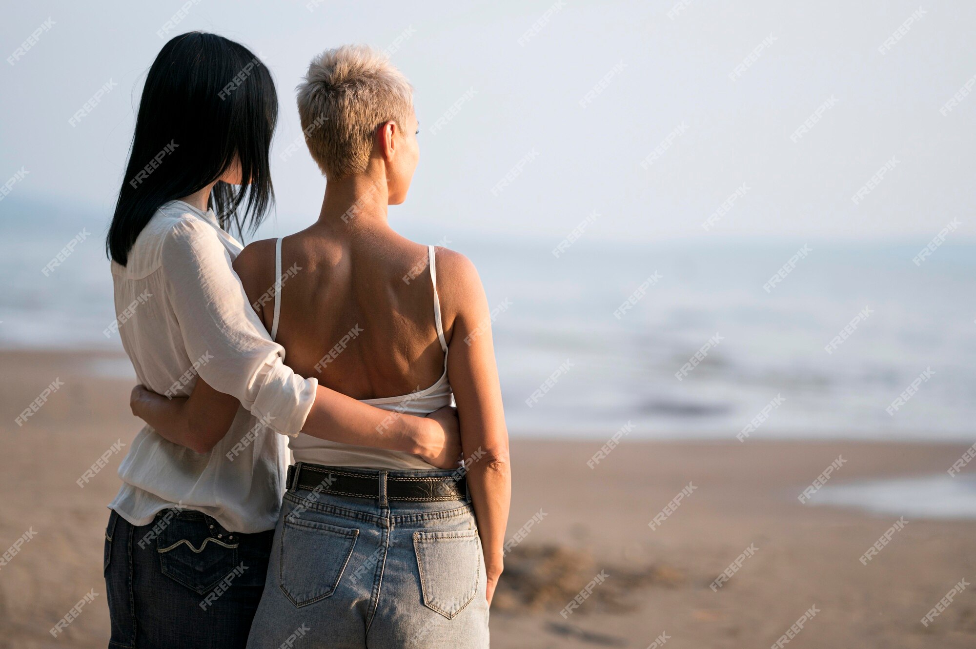 Casal de lésbicas amoroso em um encontro à beira-mar e montanhas