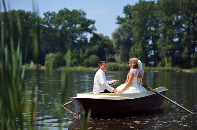 Jovem casal de noivos navegando no barco