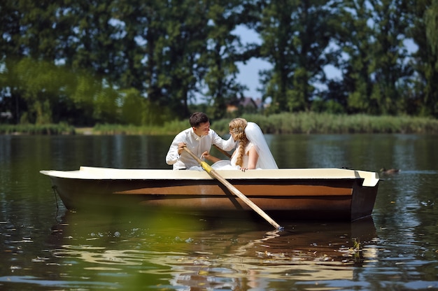 Jovem casal de noivos navegando no barco