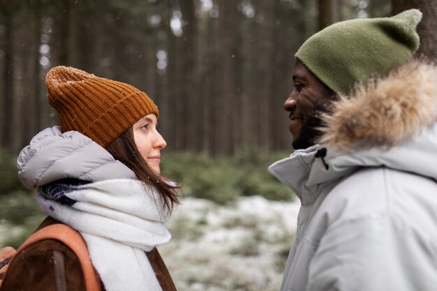 Jovem casal em uma viagem de inverno juntos, caminhando pela floresta