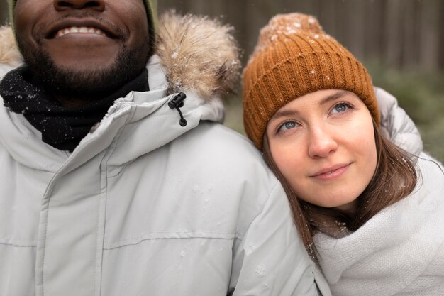 Jovem casal em uma viagem de inverno juntos, caminhando pela floresta