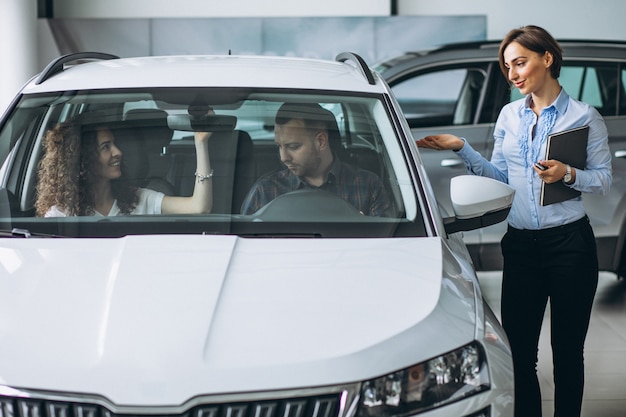 Foto grátis jovem casal escolhendo um carro em um show room de carro