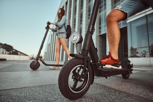 Foto grátis jovem casal está fazendo uma composição interessante de suas scooters enquanto posava para o fotógrafo.