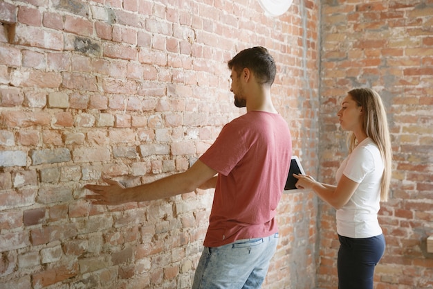 Jovem casal fazendo conserto de apartamento juntos. homem e mulher casados fazendo reforma ou reforma em casa